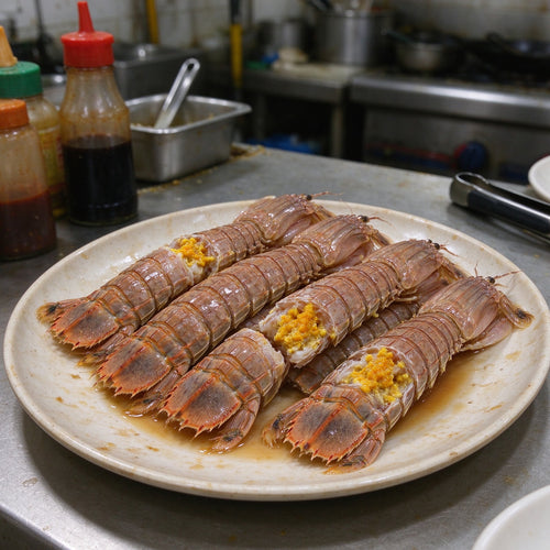 Cooked mantis shrimp with orange roe arranged on a white plate