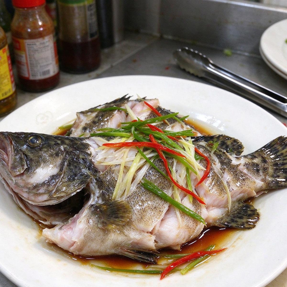 Whole steamed grouper garnished with scallion and chilli